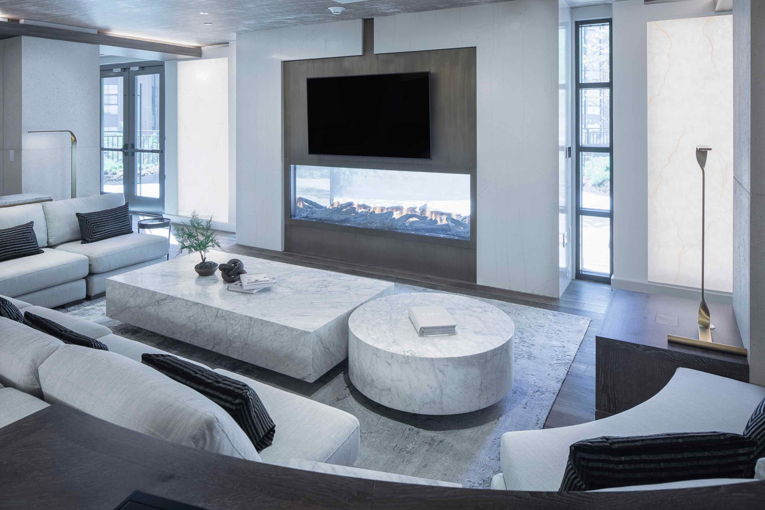 Clubroom featuring plush couches, a flat screen TV, & marble coffee tables. One of the amenities of 250 Mission in Baltimore, MD.