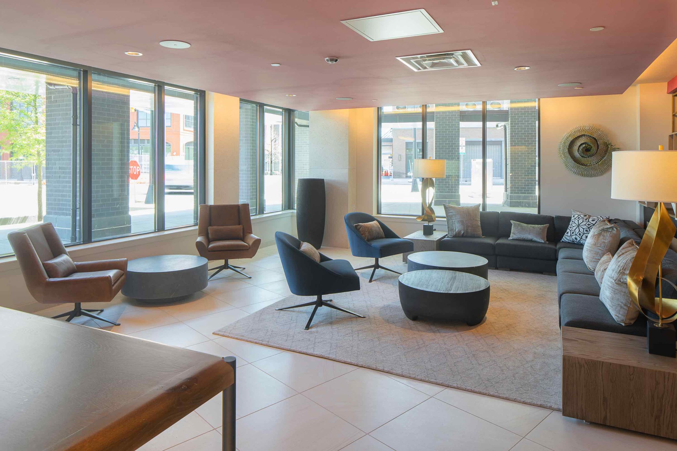 Modern apartment building lobby with ample seating & large windows. One of the amenities of 250 Mission in Baltimore, MD.