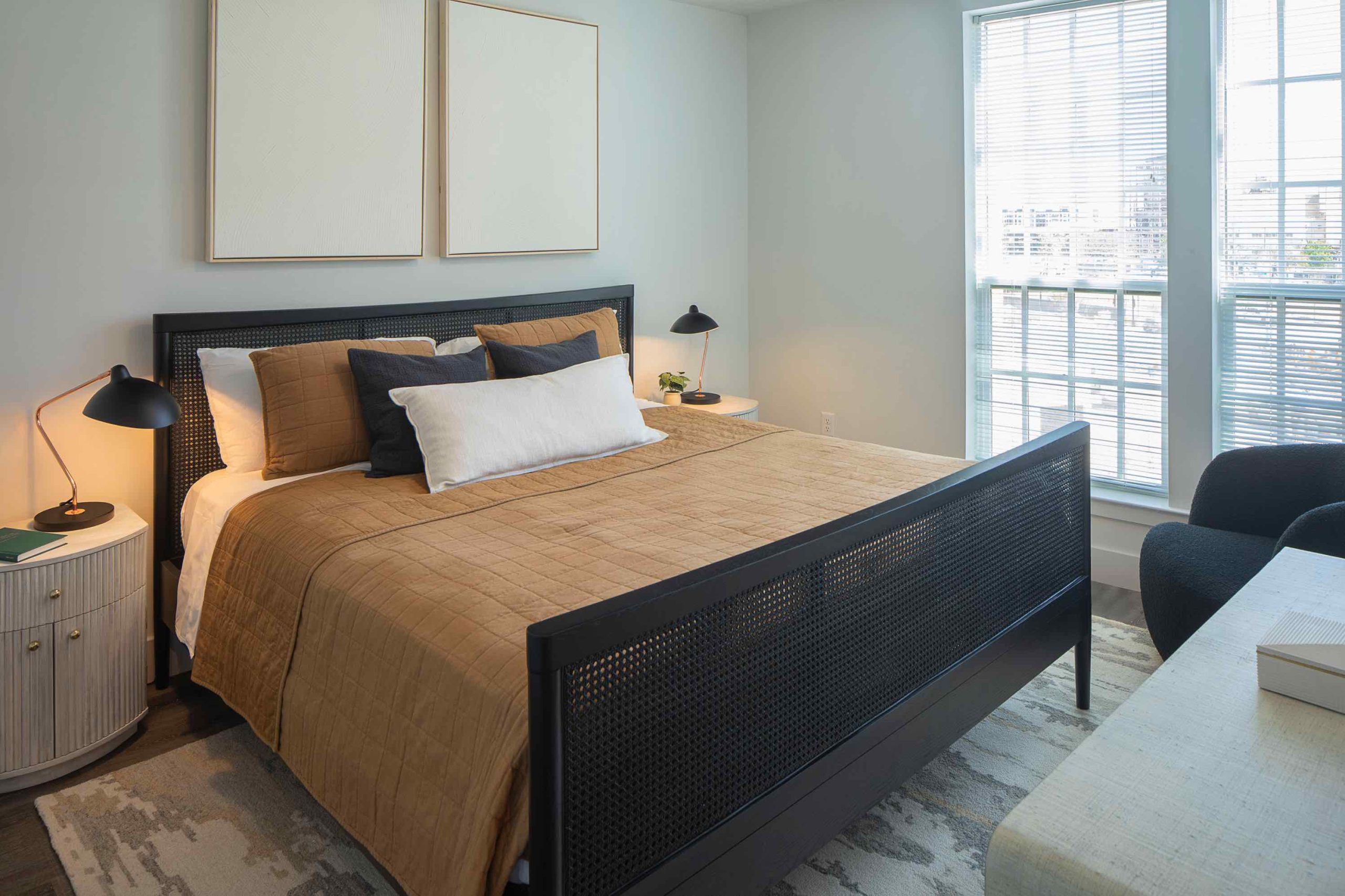 Bedroom with a comfy bed, a nightstand, a window letting in natural light. Inside our luxury apartments at 250 Mission.